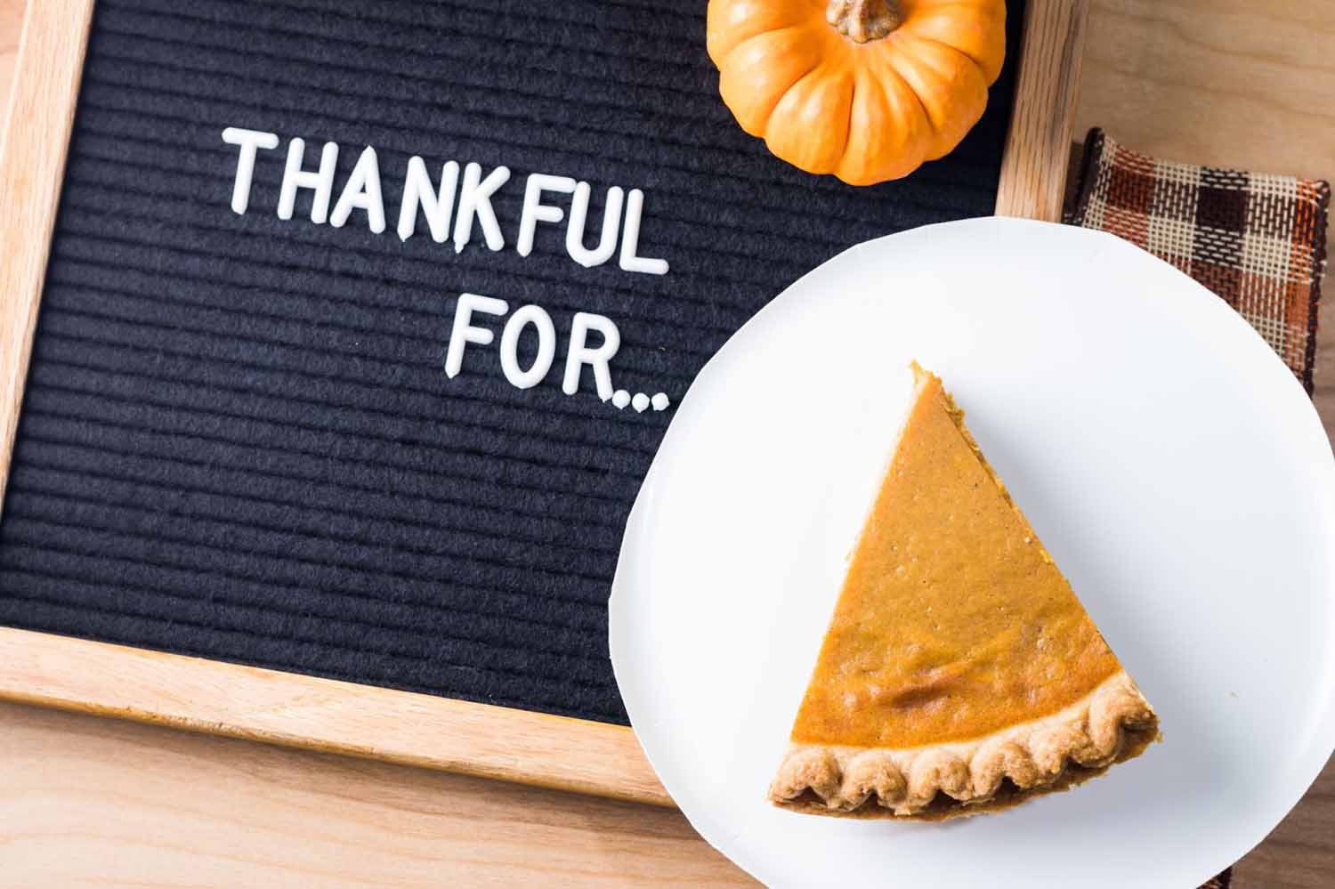Felt letterboard that says ‘thankful for…’ next to a piece of pumpkin pie