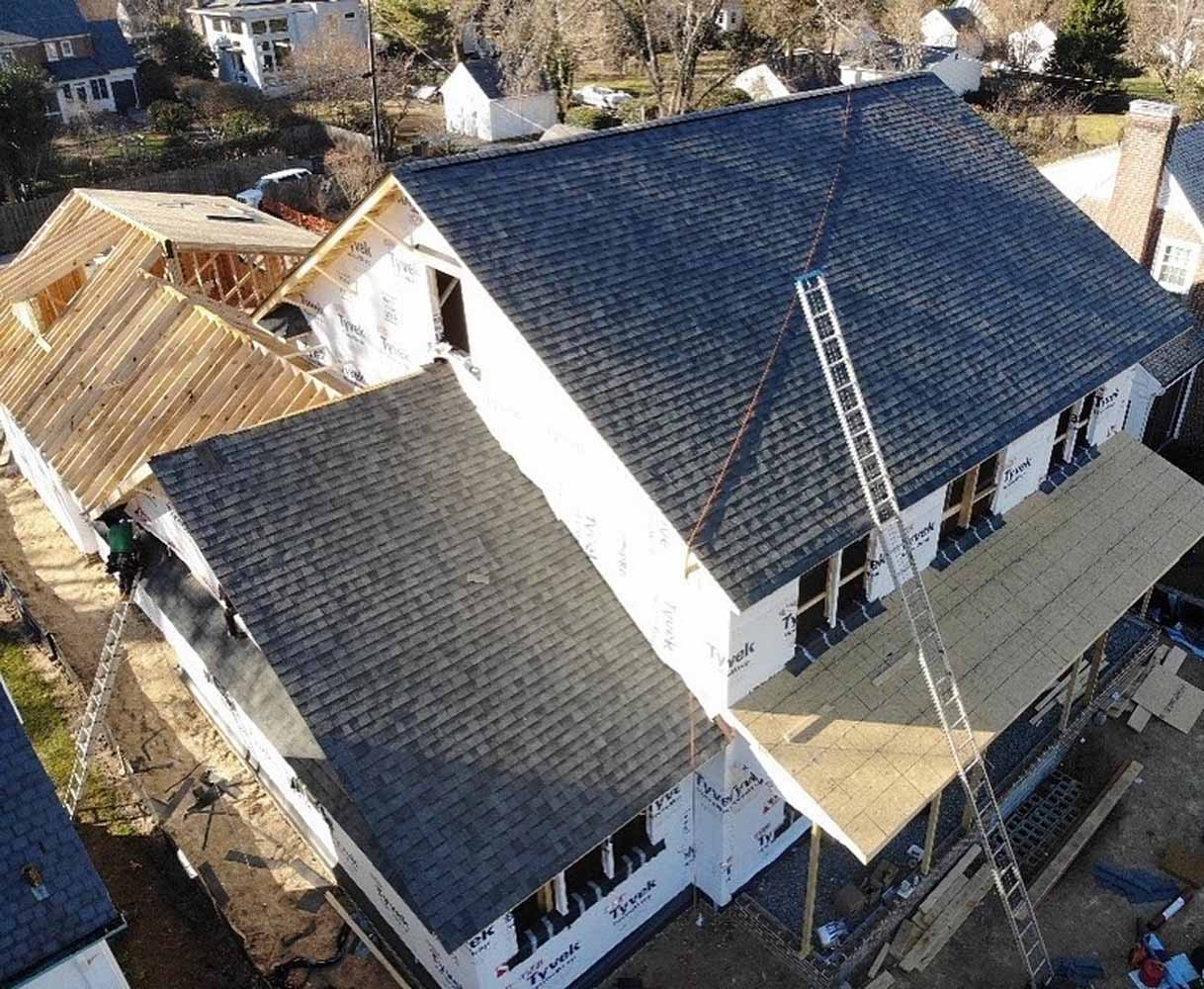 New construction home with black asphalt shigle roof being installed