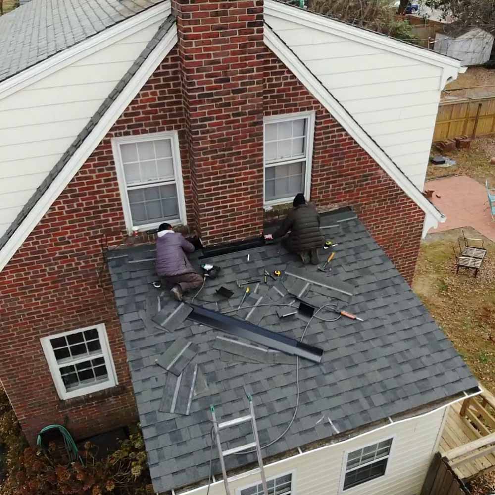 Hammersmith roofers bundled up in the winter, replacing a shingle roof