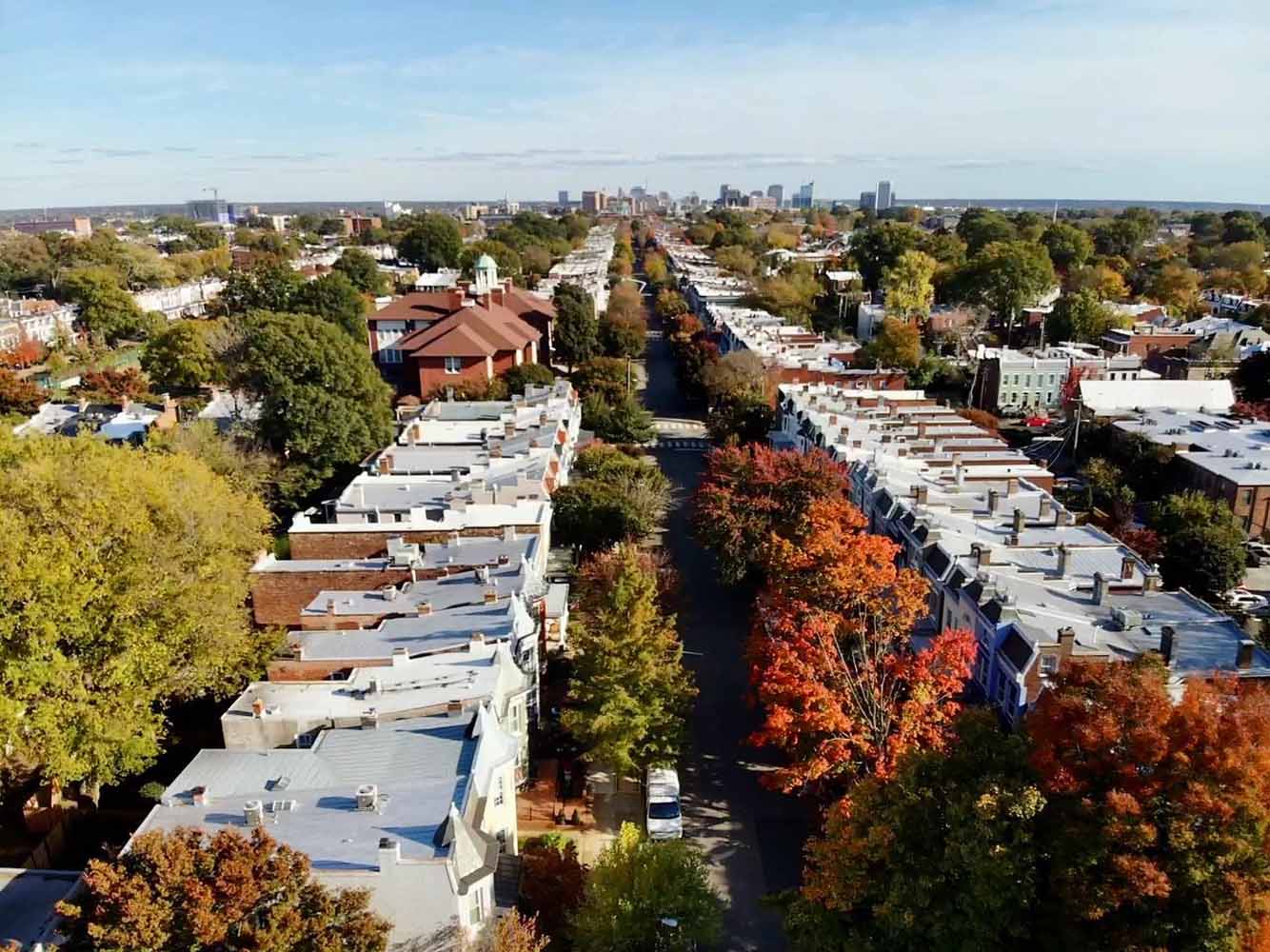 Overhead shot of a street in Richmond, VA showcasing beautiful fall trees and many historic, flat-top roofs that Hammersmith has worked on over the years