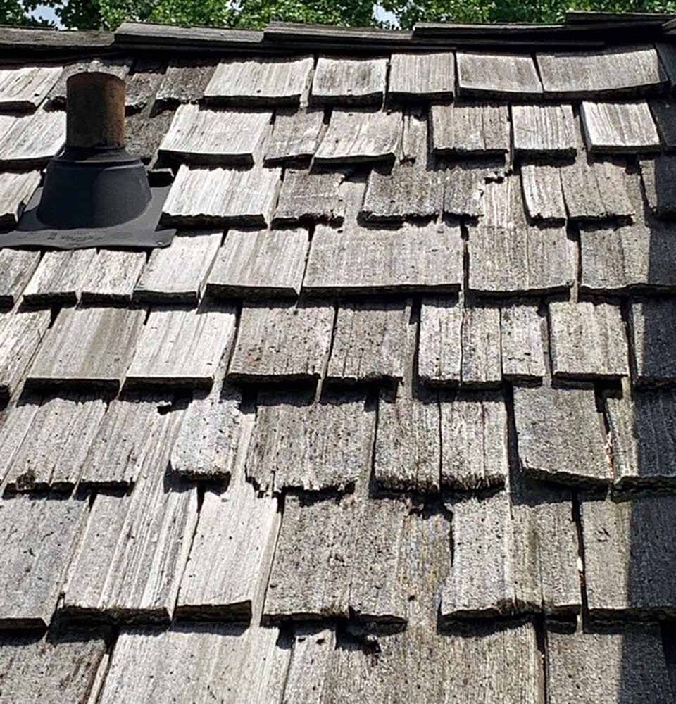 Old, wood shingles that are past their useful life expectancy and need to be replaced