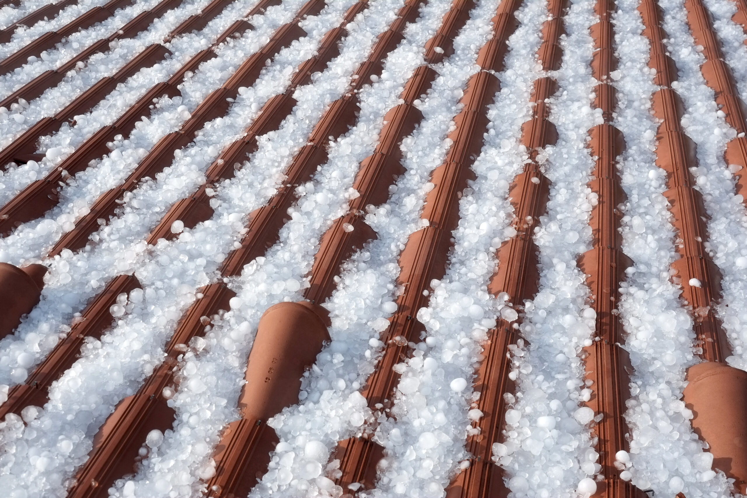 Hailstones covering an orange roof