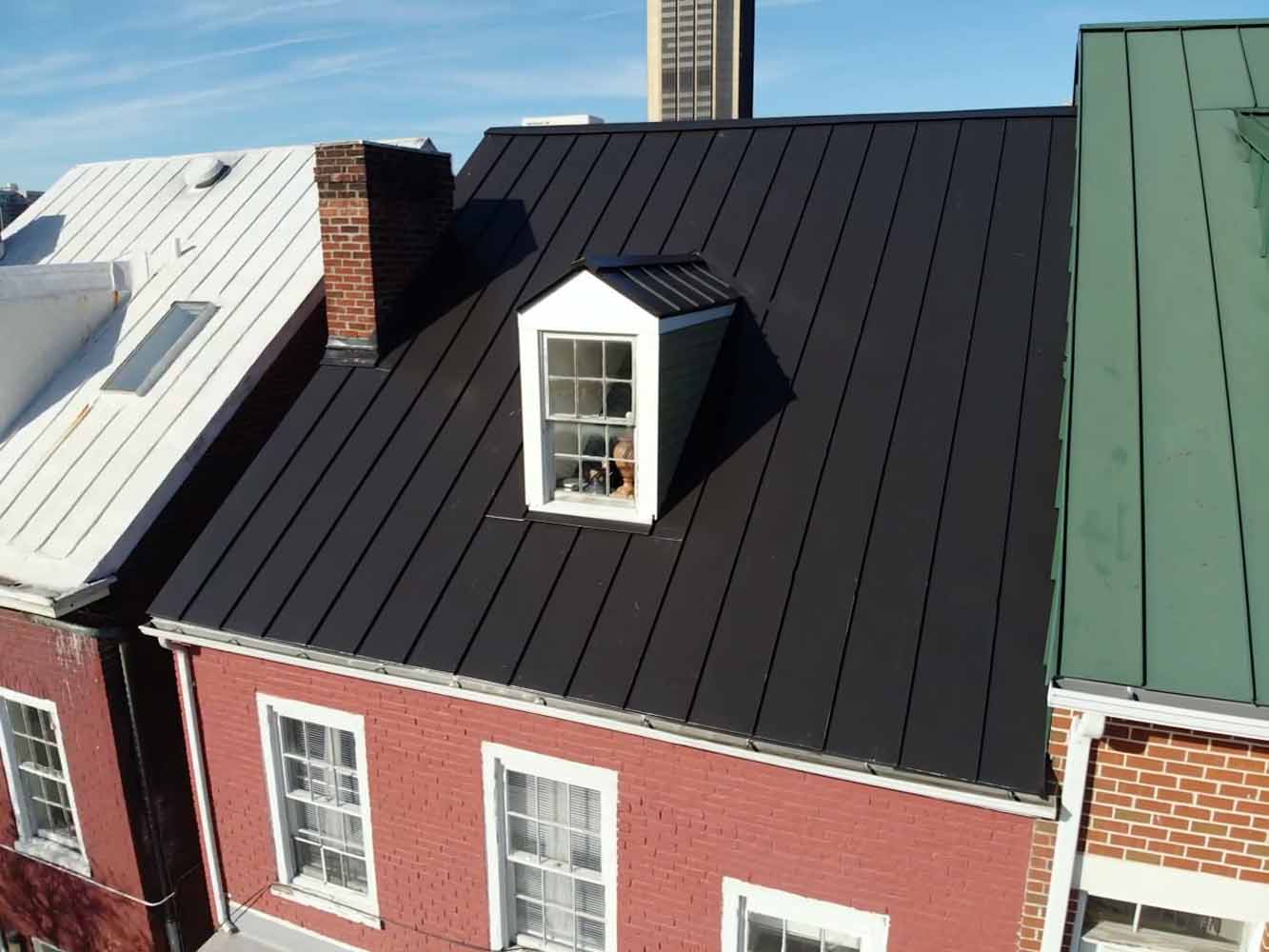 Brick row homes with silver, black and green roofs