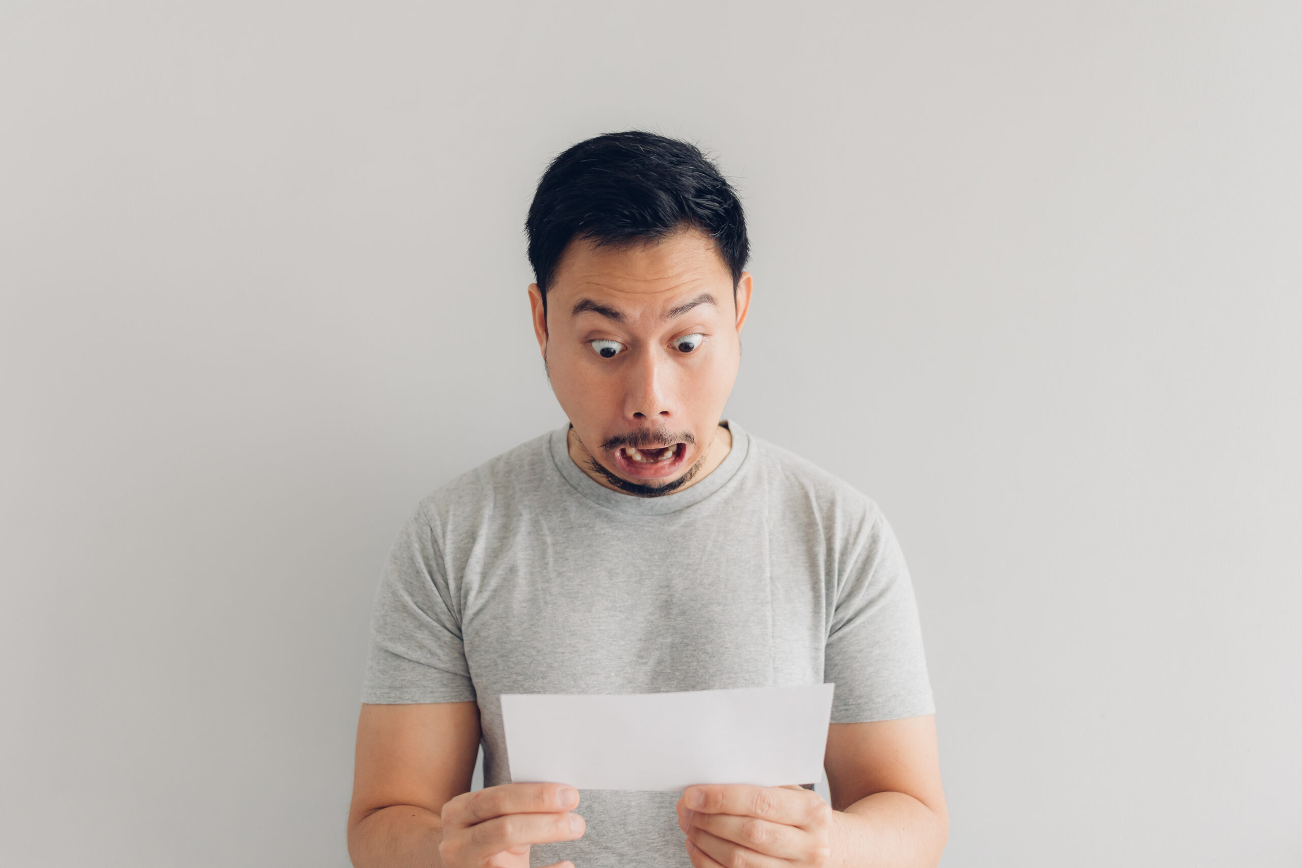 Man is shocked and surprised looking at his high energy bill due to his old roof