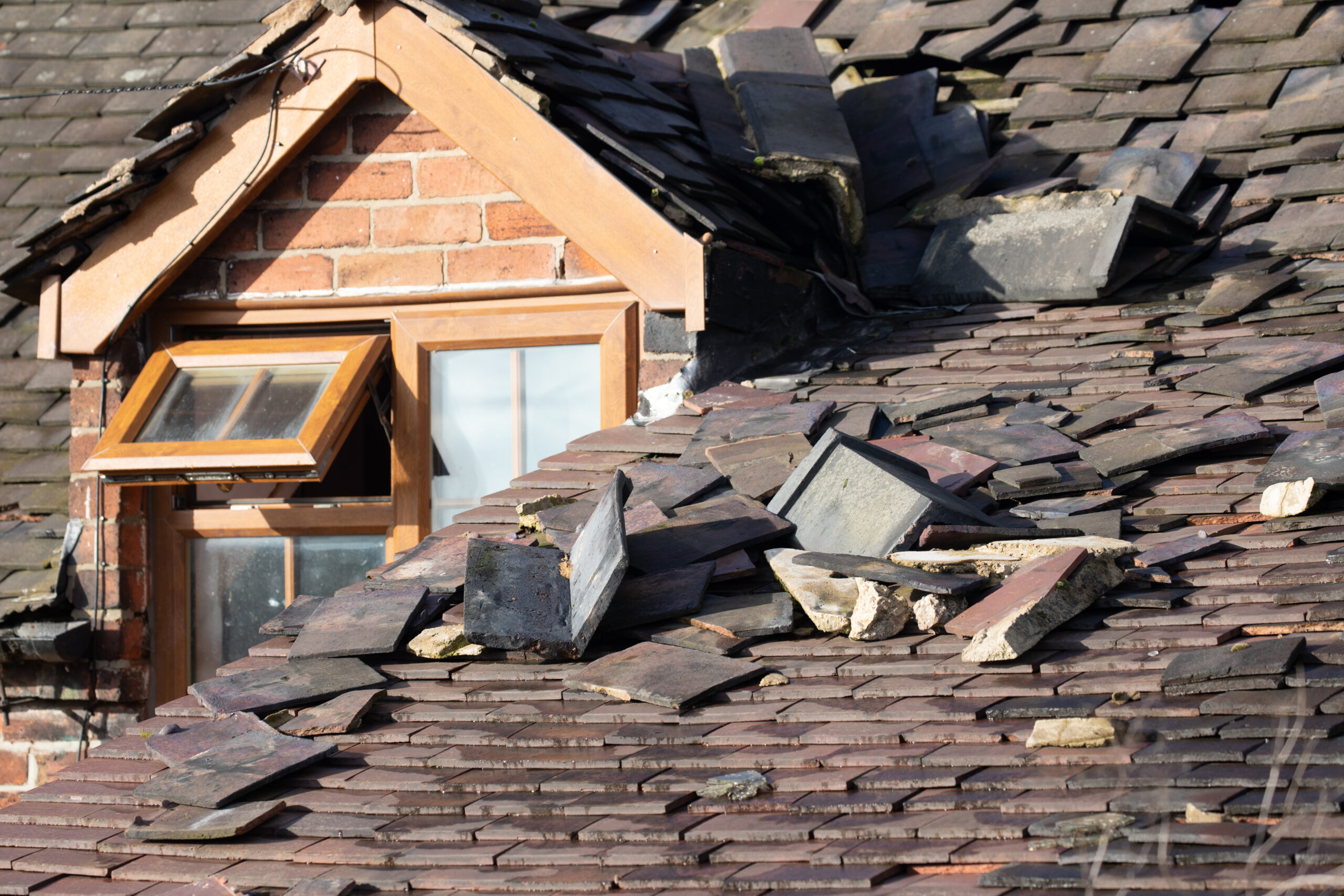 Heavily damaged slate roof after a storm