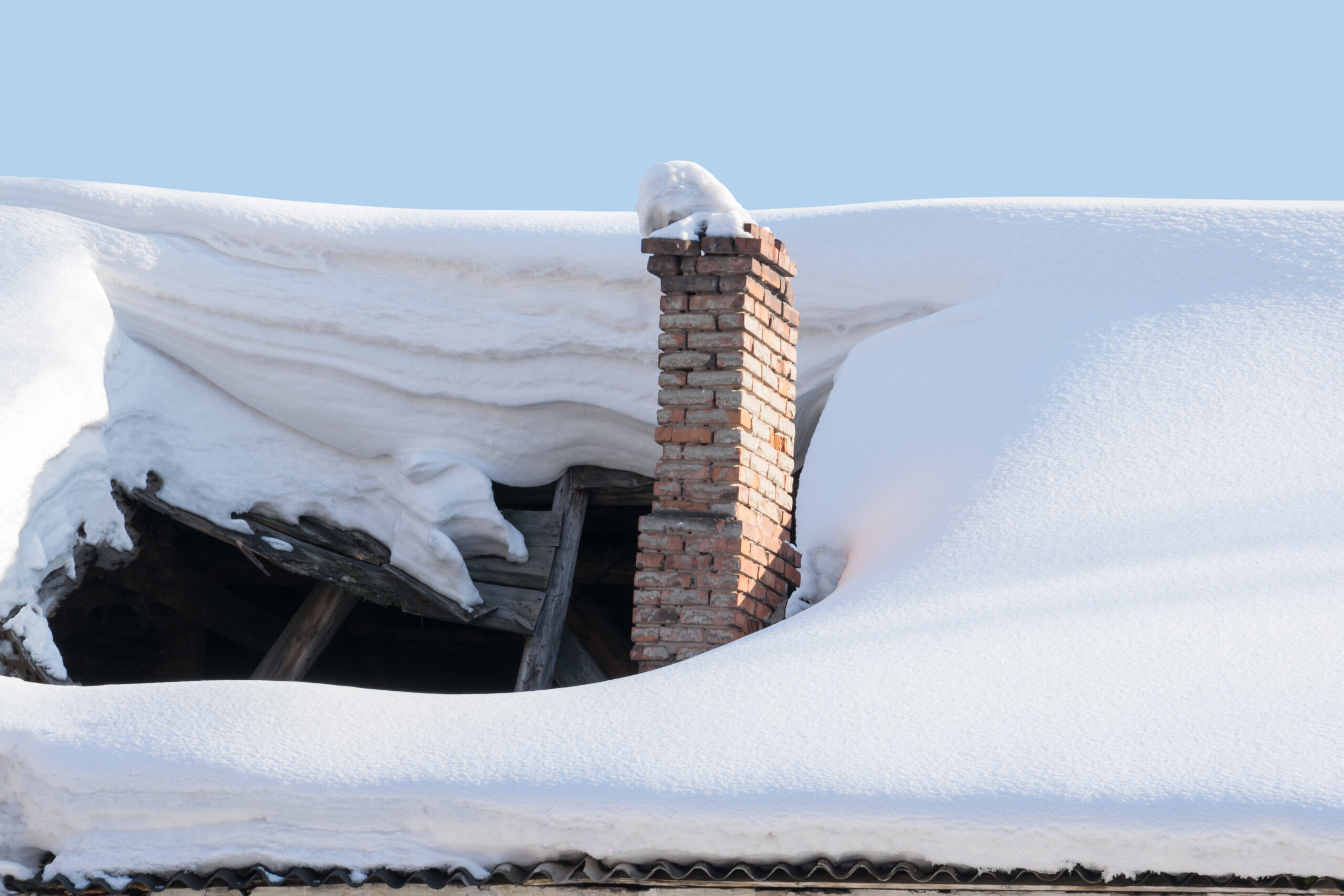 Roof collapse under weight of snow and ice, brick chimney